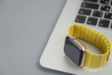 Minsk, Belarus - 12 Nisan 2021: Laptop klavyesinde sarı kayışlı Apple Watch. Boşluğu kopyala