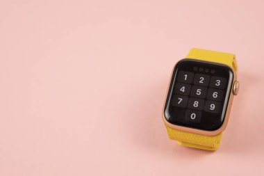 Minsk, Belarus - 14 Nisan 2021: apink arkaplanda sarı kayışlı Apple Watch. Boşluğu kopyala