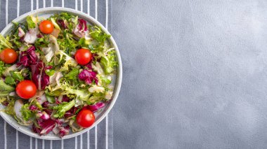 Tabakta diyet salatası: taze marul ve domatesleri karıştır. Üst görünüm, alanı kopyala