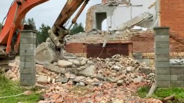 Ev binasının yıkımı. Kazıcı evi yıkıyor.