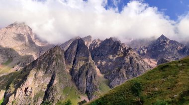Rocky dağları yaz günü mavi gökyüzünde beyaz bulutlarla görünür.