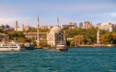 İstanbul 'un Beyoğlu ilçesindeki Dolmabahce Camii' nin önündeki Kabatas feribot terminalinden kalkan turistik tekneyle İstanbul Boğazı kıyısına bakın.