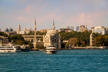 İstanbul 'un Beyoğlu ilçesindeki Dolmabahce Camii' nin önündeki Kabatas feribot terminalinden kalkan turistik tekneyle İstanbul Boğazı kıyısına bakın.
