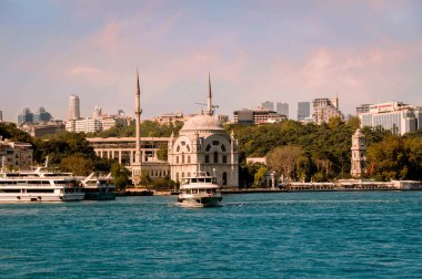 İSTANBUL, TURKEY - 09 07: 2020: İstanbul 'un Beyoğlu ilçesindeki Dolmabahçe Camii' nin önündeki Kabatas feribot terminalinden kalkan turistik botla İstanbul Boğazı kıyısına bakın