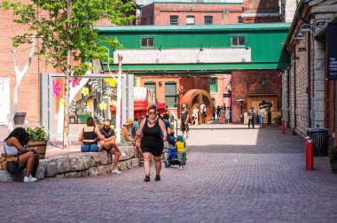 TORONTO, CANADA - 06 05 2021: Torontonlular güneşli havanın tadını çıkarıyorlar ve en büyük Candian şehrinin tarihi bölgesinde ev düzenini kaldırıyorlar - Toronto