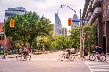 TORONTO, CanADA - 06 05 2021: Torontonlular güneşli havanın tadını çıkarıyorlar ve ev siparişlerinde kalıyorlar. Uzun süre karantina altında kaldıktan sonra bisiklet sürmek iyi bir egzersizdir.