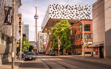 TORONTO, CANADA - 06 05 2021: Toonto şehir merkezindeki McCaul Caddesi boyunca güneşli yaz günü manzarası, önde modern OCAD Üniversitesi binası ve arkada CN Kulesi