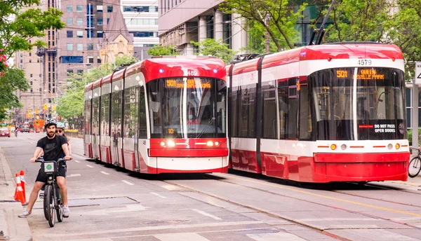 TORONTO, CANADA - 06 05 2021: Nové bombardéry TTC tramvaje sdílející silnici s cyklisty na King Street v centru Toronta. Toronto Transit Commission je agentura veřejné dopravy, která — Stock fotografie