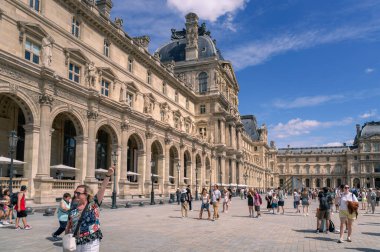 Paris, Fransa - 08 04 2023: Birinci bölgedeki tarihi Louvre Müzesi 'nin geniş açılı manzarası. Görüntü, Richelieu Kanadı 'nın karmaşık Rönesans ve Barok mimarisini avluda uluslararası ziyaretçi kalabalığıyla sergiliyor.