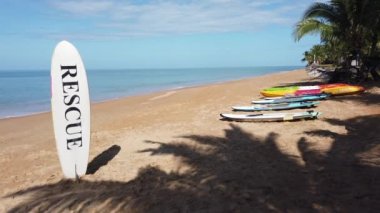 Phangnga sahilindeki sörf tahtası. Kum ve gökyüzü. Nang Tanga Sahili, Phangnga, Tayland 'da. Yazın manzara manzarası. Güzel sahil, Andaman Denizi 'nde ünlü bir turizm merkezidir. 4K