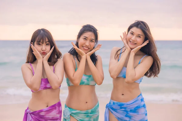 Three young women friends happily wear this bikini on a beach in Nai Thon Beach, Phuket Province, Thailand. Portrait of happy young woman smiling at sea. Concept about Travel, happiness, nature.