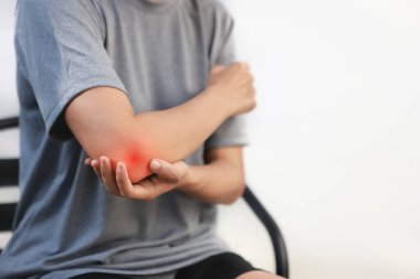 Akut dirsek ağrısı ve eklem iltihabı olan genç bir kadın, kırmızı röfle efektli, hassas koluna dokunan bir kadın, tendonit, spor yaralanması, eklem iltihabı, sağlık sorunu, fotokopi alanı geçmişi.