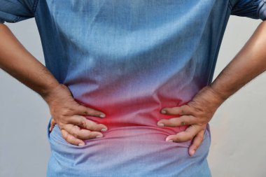 Orta yaşlı Asyalı adam otururken kronik sırt ağrısı ya da ofis sendromu geçiriyor. Belinde kırmızı iltihaplı bölge, böbrek sorunu, omurilik hasarı ve ortopedik sağlık konsepti..