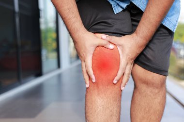 Kırmızı iltihaplı diz ağrısı çeken Asyalı bir adam. Yetişkin hastalarda osteoartrit, menisküs hasarı, gut, romatizma ve ortopedik tıbbi tedavi kavramı.