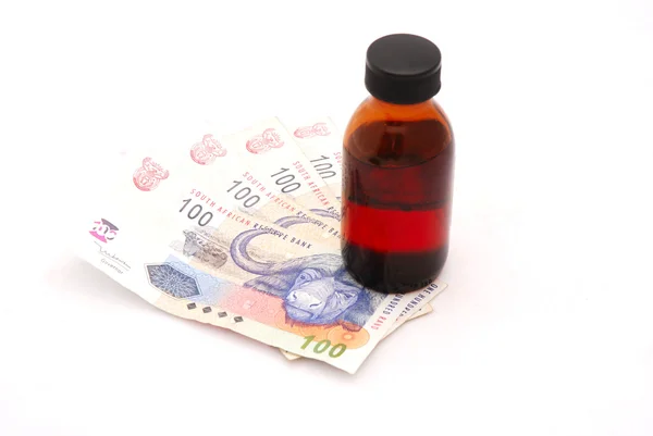Skleněná láhev medicíny stojícího na peníze Royalty Free Stock Obrázky