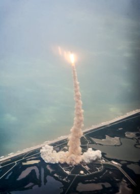 Uzay mekiği Atlantis, fırlatma rampası 39A 'dan fırlatılan bir Uzay Mekiği Eğitim Uçağı' nın (STA) penceresinden görülüyor. Arkaplan şablonu, Nasa tarafından desteklenen bu resmin ögeleri