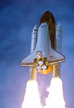 Uzay mekiği Discovery, STS-120 görevinde uzaya doğru mavi Florida semalarında gürlerken roket iticilerinden iki kolon ateş püskürtüyor. Arkaplan şablonu, Nasa tarafından desteklenen bu resmin ögeleri
