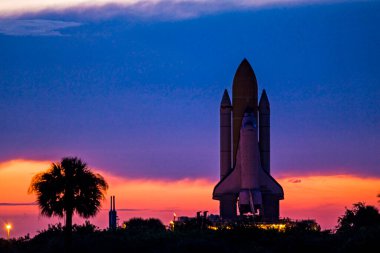 Uzay mekiği Discovery, NASA & Kennedy Uzay Merkezi 'ndeki fırlatma rampası 39A' ya doğru yol alırken, şafak vakti gökyüzüne karşı siluetlendi. Bu görüntünün unsurları NASA tarafından desteklendi.