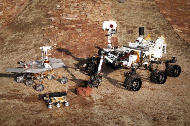 Bu iki test aracı ve bir uçuş yedeği grubu, NASA tarafından desteklenen bu görüntünün elementlerini geliştiren Mars gezginlerinin üç nesillik bir arkaplan şablonunun grafiksel karşılaştırmasını sunuyor.