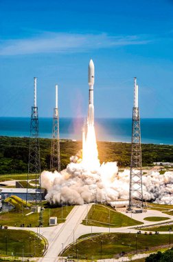 Ateş ve dumandan yükselen NASA Juno gezegen sondası, kargo kaplamalarıyla çevrili, Birleşik Fırlatma İttifakı Atlas V roketinin tepesine fırlatılıyor. Arkaplan şablonu, Nasa tarafından desteklenen bu resmin ögeleri