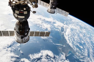 Soldaki uzay aracı, Nasa tarafından desteklenen, Dünya 'ya bakan port elemanlarına bağlı Rassvet modülüne bağlı.