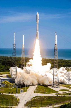 Ateş ve dumandan yükselen NASA Juno gezegen sondası, kargo kaplamalarıyla çevrili olarak, bir Birleşik Fırlatma İttifakı Atlas V roketinin tepesine fırlatılıyor. Arka plan şablonu - NASA tarafından desteklenen bu resmin elementleri