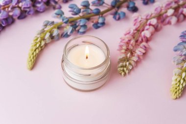 Pembe arka planda mum ve lupin çiçekleri