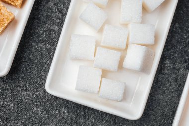 Kahveyi ya da tatlı servisini beklerken, tepside beyaz şeker kalıpları düzgünce yerleştirilmiş..