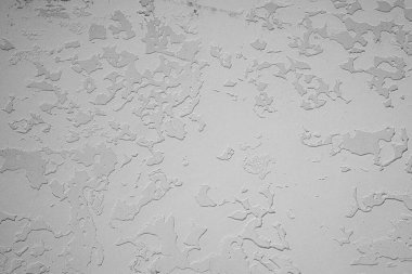 Düz olmayan sanatsal yüzeyi ve pürüzlü yamayla beyaz desenli alçı duvar