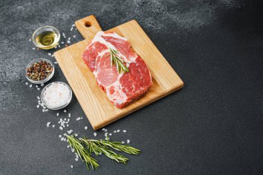 Biberiyeli çiğ biftek ve ahşap tahtada baharatlar.
