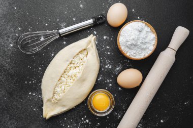 Çiğ khachapuri ile kaplanmış yüzey, yumurta ve fırın için merdane.