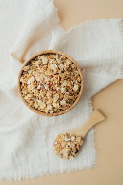 Tahta kase ve kaşık, beyaz kumaş kaplamalı granola.