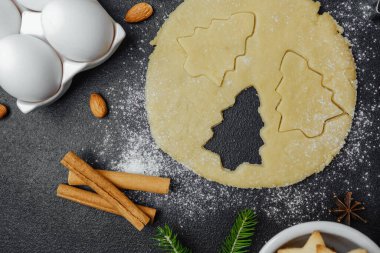 Mevsimsel kutlama yiyecekleri konsepti için badem malzemesi ve köknar dallarıyla yapılan tatil kurabiyeleri.