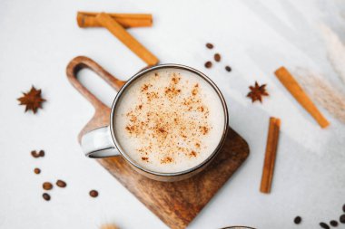 Tahtada tarçın ve baharatla kaplı ılık kremalı kahve içeceği.