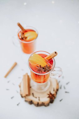 İki bardak sıcak kış baharatı portakal dilimleri ve tarçın çubuklarıyla sıcak şarap.