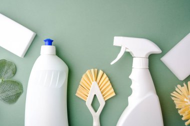 Yeşil arka planda yeşil yapraklı beyaz temizlik malzemeleri.