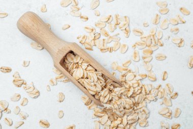 Kurutulmuş yulaf, ahşap bir kepçeden mutfak tezgahına dökülüyor..