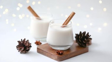 Tarçın çubukları ve kozalaklı iki kış içkisi, şenlikli Bokeh ışıkları arka plan.