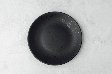 Parlak siyah bir plaka, ışık yüzeyinde benekli bir tasarım içerir..