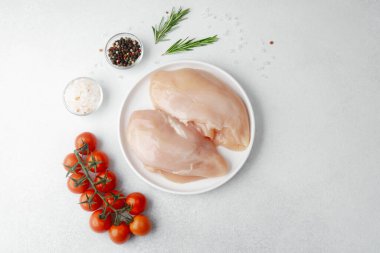 Tuz, biber, biberiye ve kiraz domatesli çiğ tavuk göğsü.