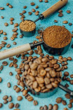 Kahve, hazır kahve ve mavi arka planda kepçelerle fasulye.