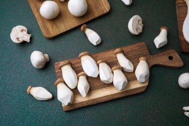 Hasat çeşitliliği veya vejetaryen pişirme konsepti için koyu yeşil arka planı olan çeşitli mantarlar.