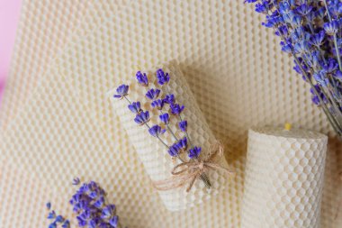 Balmumu mumlar ve pembe arka planda lavanta demetleri