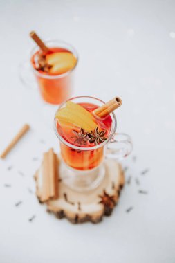 Two warming winter drinks mulled wine with orange and cinnamon sticks in glasses