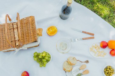 Yaz havası, tazelik ve açık hava yemek kavramları için çerez, meyve ve şarap içeren piknik battaniyesinin en üst görüntüsü.