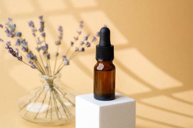 Cam vazoda lavanta çiçekleri arasında kehribar damlası şişesi