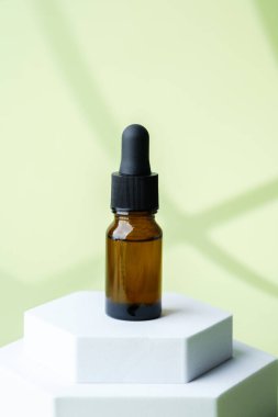 Siyah kapaklı kahverengi cam kozmetik damlası şişesi.