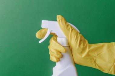 Sarı eldiven giymiş, yeşil arka planda beyaz sprey baskılı tetik var..