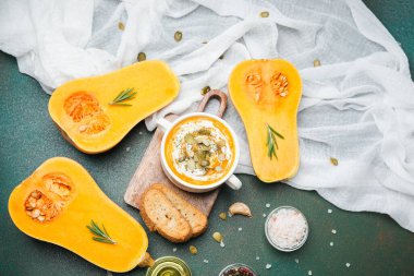 Butternut squash halves with soup and rosemary sprigs on table