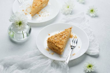Beyaz tabakta kremalı ve börek dilimli Millefeuille pastası tatlısı.